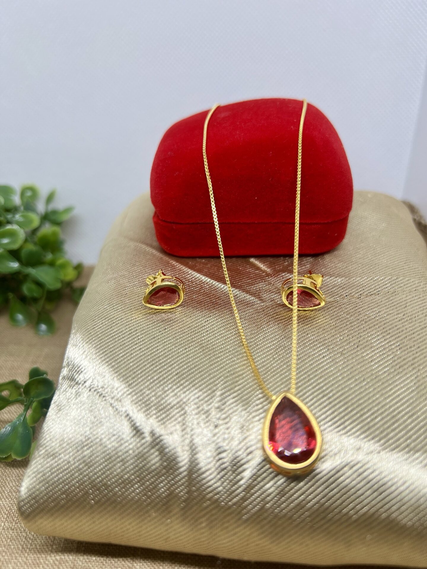 O conjunto colar e brinco coração vermelho banhado a ouro 18k é a personificação da elegância e do amor. Com detalhes minuciosamente trabalhados, este conjunto é ideal para quem deseja adicionar um toque sofisticado e romântico ao seu visual.